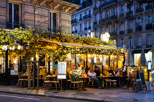Fashionable decorations in Paris : a lot of flowers in a charming and romantic café. Montparnasse quarter in Paris December 15th, 2023