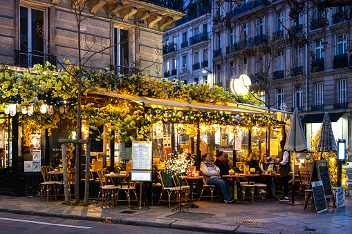 Turin, Italy - June 18, 2017: The Quadrilatero, night life and restaurant district of Turin (Italy) at evening, on june 18, 2017, with people sitting at the tables, eating and walking