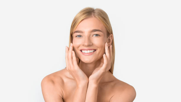 istock blonde millennial lady touching flawless face on white studio backdrop 2001377655