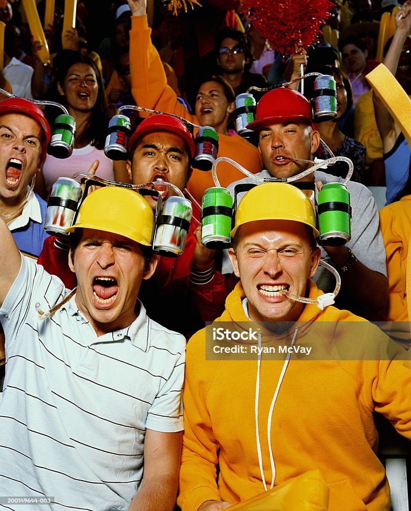 Grupo de jóvenes hombres usando cascos potable, aclamando en multitud - Foto de stock de Cerveza libre de derechos