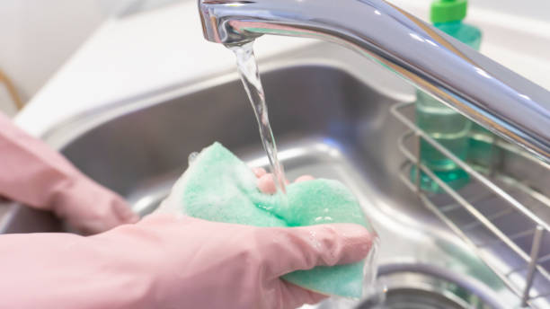 istock person washing dishes in the kitchen 2001497479