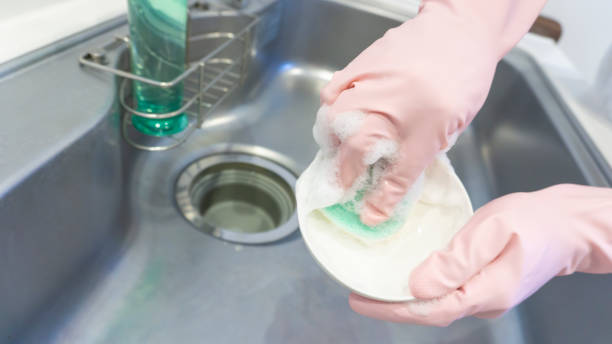 istock person washing dishes in the kitchen 2001498568