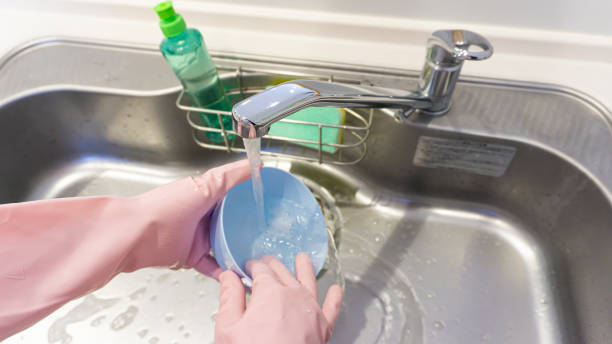 istock person washing dishes in the kitchen 2001498578