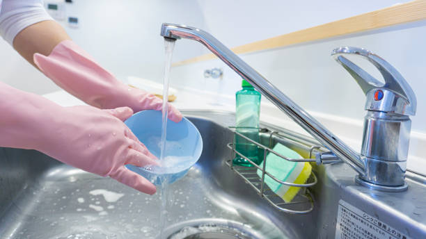 istock person washing dishes in the kitchen 2001499125