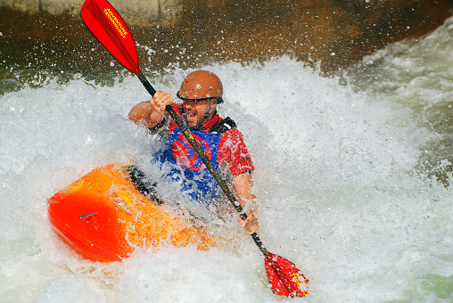 Charlotte, NC, USA June 16, An adult man practices his kayaking skills in rough rapids at the US Whitewater Center in Charlotte, North Carolina;