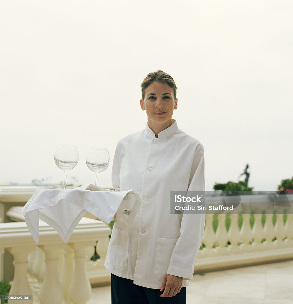 Waitress holding tray with wine glasses, portrait  Caterer Stock Photo