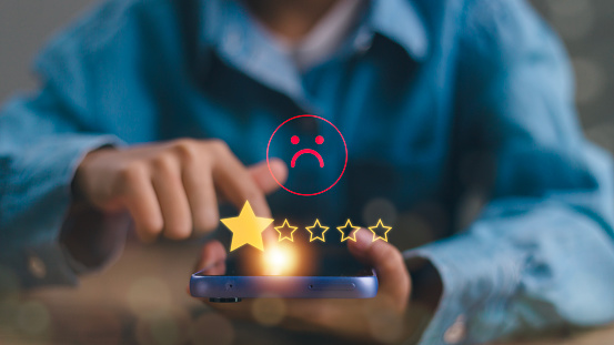 Businessmen chose a 1-star rating review in the survey on the virtual touch screen on smartphones. Bad review, bad service dislike bad quality, low rating, social media not good