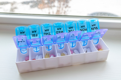 A full pill box or vitamin organizer with the days of the week separated individually by am and pm to help remind when medication should be taken.