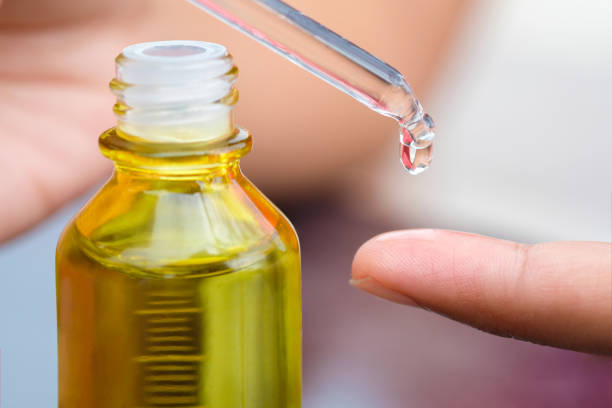 istock Dropping serum collagen moisturizer of face into clear yellow bottle soft light background. Protector skin Treatment facial essence oil, Vitamin C. Beauty and spa Concept. 2001684240