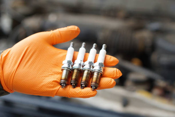 close up mechanic hands hold old spark plug, spare part of car engine. concept, machine maintenance, fix, repair, check or diagnose automobile problems by engine specialist. - spark plug electrode transportation workshop stock-fotos und bilder