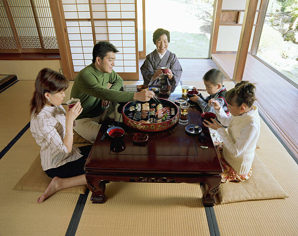 Three generation family eating sushi, elevated view boy (5-7), girl (9-11), Hayama, Japan zabuton stock pictures, royalty-free photos & images