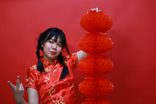 A cheering girl with a red Chinese lantern  in the studio Chinese New Year Festival concept