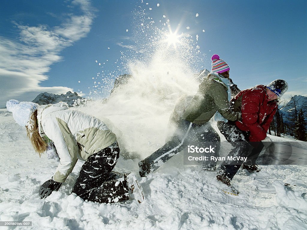 Three teenagers (15-17) roughhousing in snow, side view Methow Valley, North Cascade Mountain Range, Washington, USA Snow Stock Photo