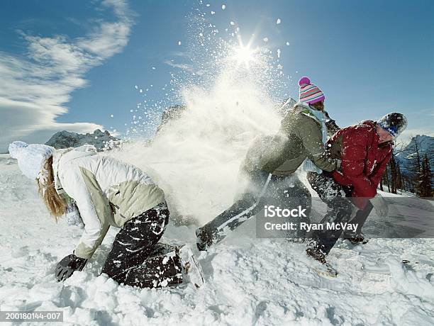 Three Teenagers Roughhousing In Snow Side View Stock Photo - Download Image Now