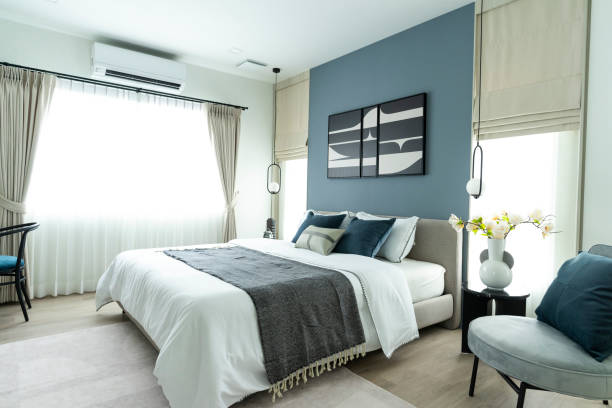 istock Stylish Bedroom with gray fabric headboard and bed with soft blue and white pillows 2001810927