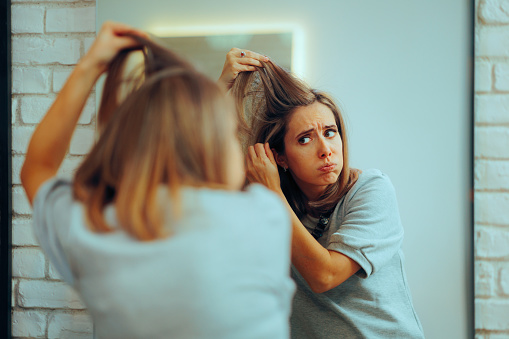 Unhappy lady experiencing hair loss and dandruff problems