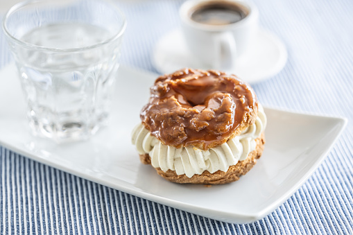 Veternik - sweet donut, typically Slovak caramel sweet cake with cream filling topped with caramel on a plate in a cafe.