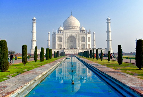 3rd February, 2020 - Agra, India: An early morning shot captures the Taj Mahal bathed in the soft, warm glow of the rising sun. The absence of haze allows for a clear and vivid representation of this iconic structure, accentuating its intricate marble inlay and grandiose architecture. Tourists and visitors in the image are seen admiring the monument, their attention captivated by its beauty and the exceptional lighting conditions. This UNESCO World Heritage site, built between 1632 and 1648, serves not only as a testament to undying love but also as a pinnacle of Mughal art and architecture.