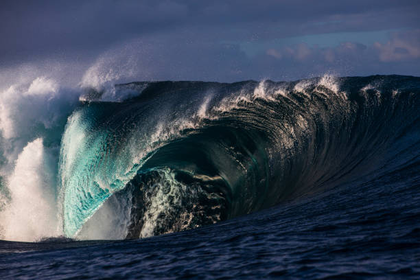 istock Powerful dangerous blue wave breaking on reef  in the ocean with warm morning light 2001932960