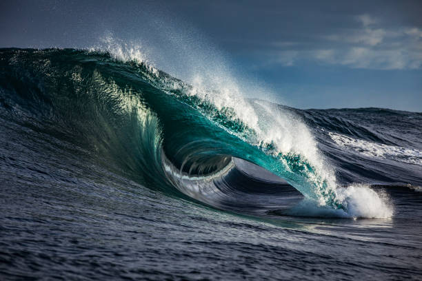 istock Powerful dangerous blue wave breaking on reef  in the ocean with warm morning light 2001946001