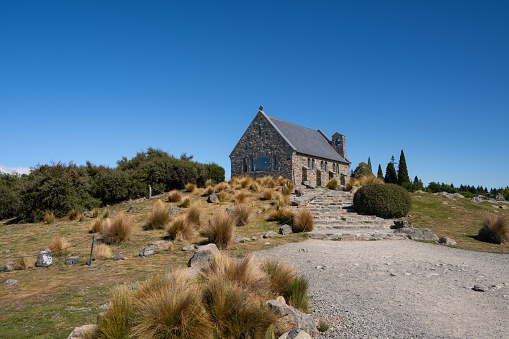 Experience the mesmerizing beauty of New Zealand's Church of the Good Shepherd under a blue sky. A celestial spectacle awaits.