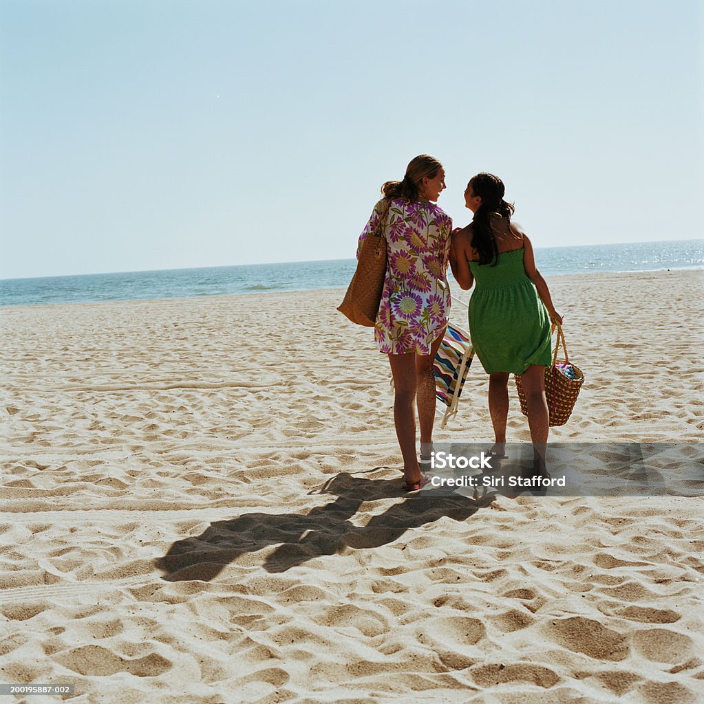 Zwei junge Frauen, die zu Fuß am Strand, von hinten - Lizenzfrei Strand Stock-Foto