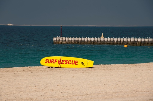 Dubai, United Arab Emirates 01 23 2024: yellow surfboard used by life guards for rescue on the sandy beach of Dubai