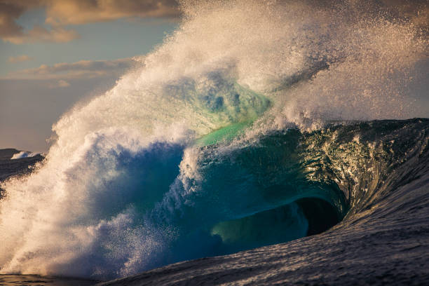 istock Powerful wave breaking on reef in the ocean with soft golden light and dramatic sky 2001966118