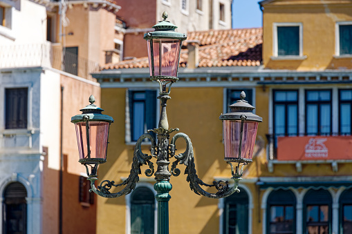 Old town of City of Venice with close-up of lantern with pink glass on a sunny summer day. Photo taken August 6th, 2023, Venice, Italy.