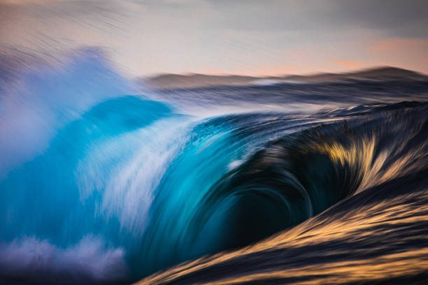 istock Slow shutter blur of unique wave breaking on reef in the ocean with dramatic golden light 2001981335
