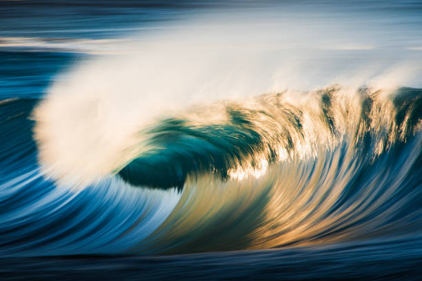 istock Slow shutter blur of smooth wave breaking on reef in the ocean with dramatic golden light 2002002320