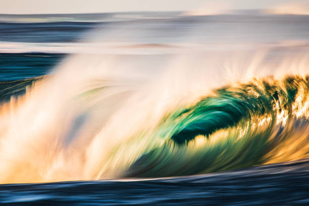 istock Slow shutter blur of smooth wave breaking on reef in the ocean with dramatic golden light 2002002839