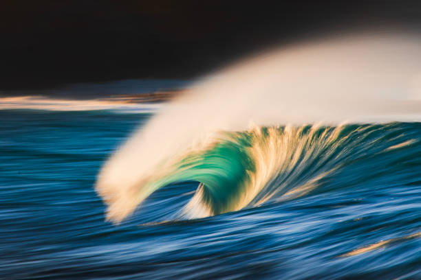istock Slow shutter blur of smooth wave breaking on reef in the ocean with dramatic golden light 2002007020