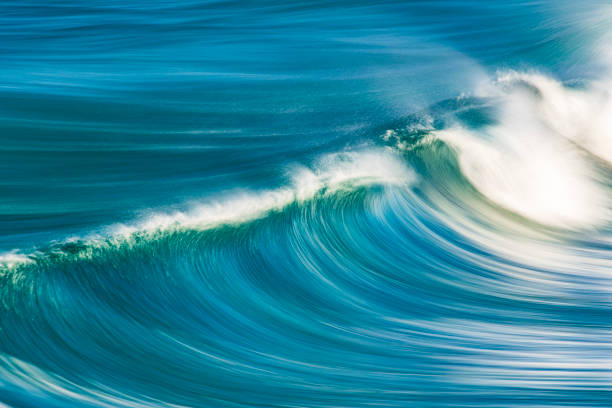istock Slow shutter blur of smooth wave breaking on reef in the ocean 2002011743