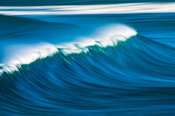 istock Slow shutter blur of smooth wave breaking on reef in the ocean 2002013303