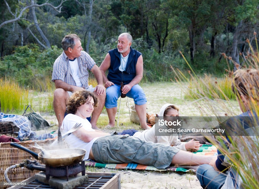 Männlichen Mitglieder einer Familie Entspannen im Freien, Fisch in der Pfanne Kochen - Lizenzfrei Fischen Stock-Foto