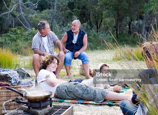 Männlichen Mitglieder Einer Familie Entspannen Im Freien Fisch In Der Pfanne Kochen Stockfoto und mehr Bilder von Fischen