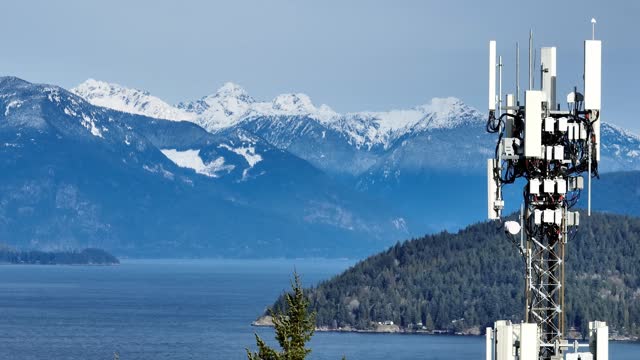Telecommunications Tower Antenna With Howe Sound And Snowy Mountains In The Background In BC, Canada. - aerial shot