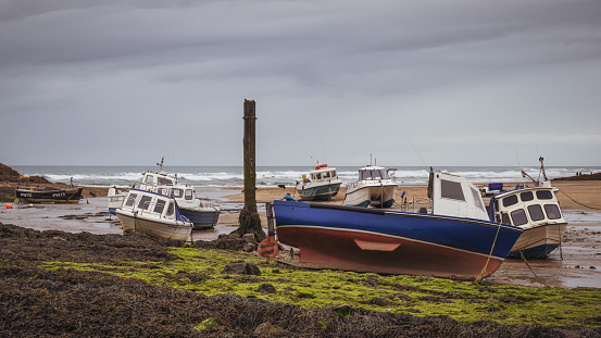 Bude, Cornwall, England, UK - June 07, 2022: Boats at low tide on the beach at Sir Thomas's Pit