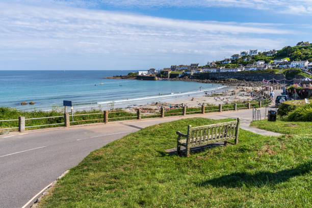 Newquay, UK. 21 May 2024. Man takes a photo of Newquay Beach from the cliff.