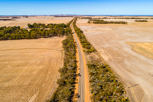 Aerial view of long straight road out through the Australian Outback.