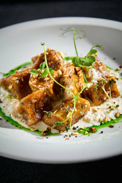 istock Crispy eggplant with stracciatella cheese and a drizzle of green sauce on a white plate, a closeup of a culinary delight 2002043350