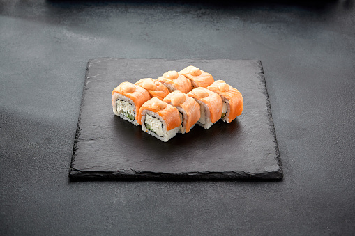 Baked Philadelphia sushi rolls with spicy sauce, offering a creamy and tangy taste in each bite.