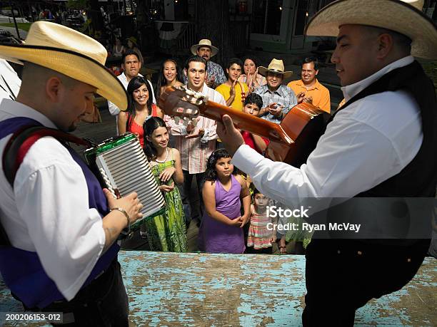 Adults And Children Watching Men Play Music On Stage Stock Photo - Download Image Now