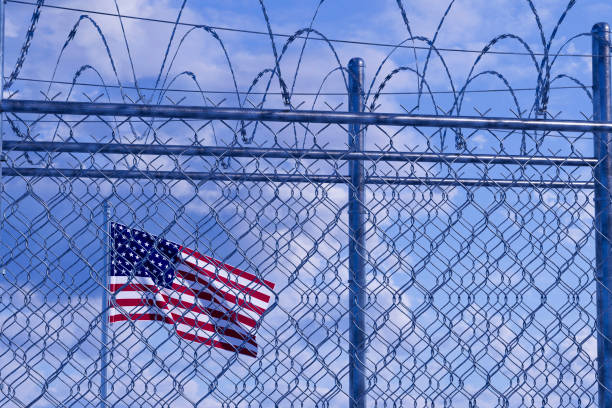 istock USA border with barbed wire and American Flag 2002067098