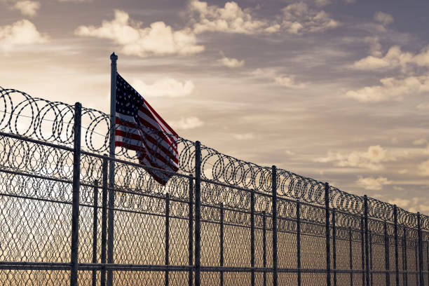 istock USA border with barbed wire and American Flag 2002067623