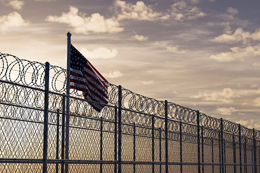 USA border with barbed wire and American Flag