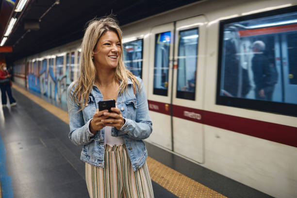 istock Young female tourist using a phone while waiting for a train 2002069692