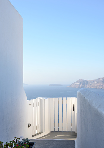 Idyllic landscapes of Santorini. Gate on the terrace against the backdrop of the blue sea.