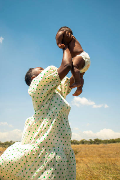 A young african mother playing  with her baby  outdoors